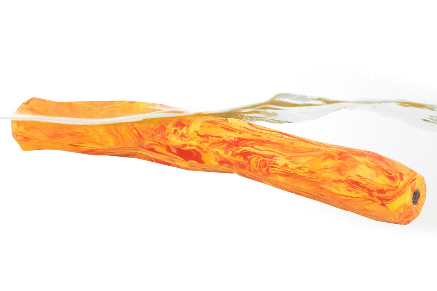 Stock image of a black and white dog picking up a Gnawt-a-Stick, in a grassy field.