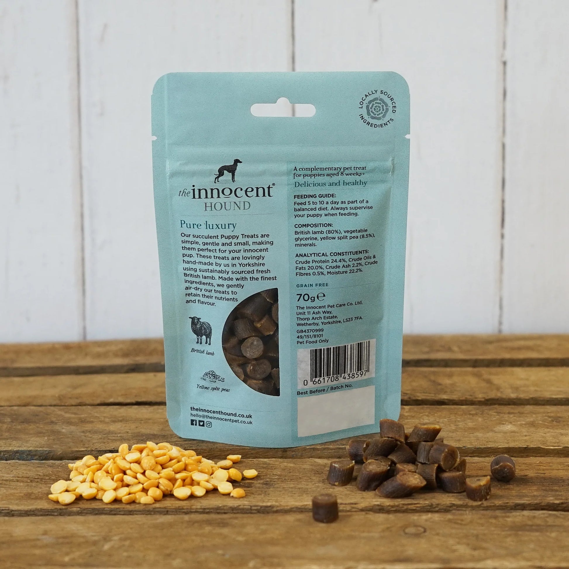 The back of the Innocent Hound Puppy Training Treats packet, on a wooden surface with treats displayed.