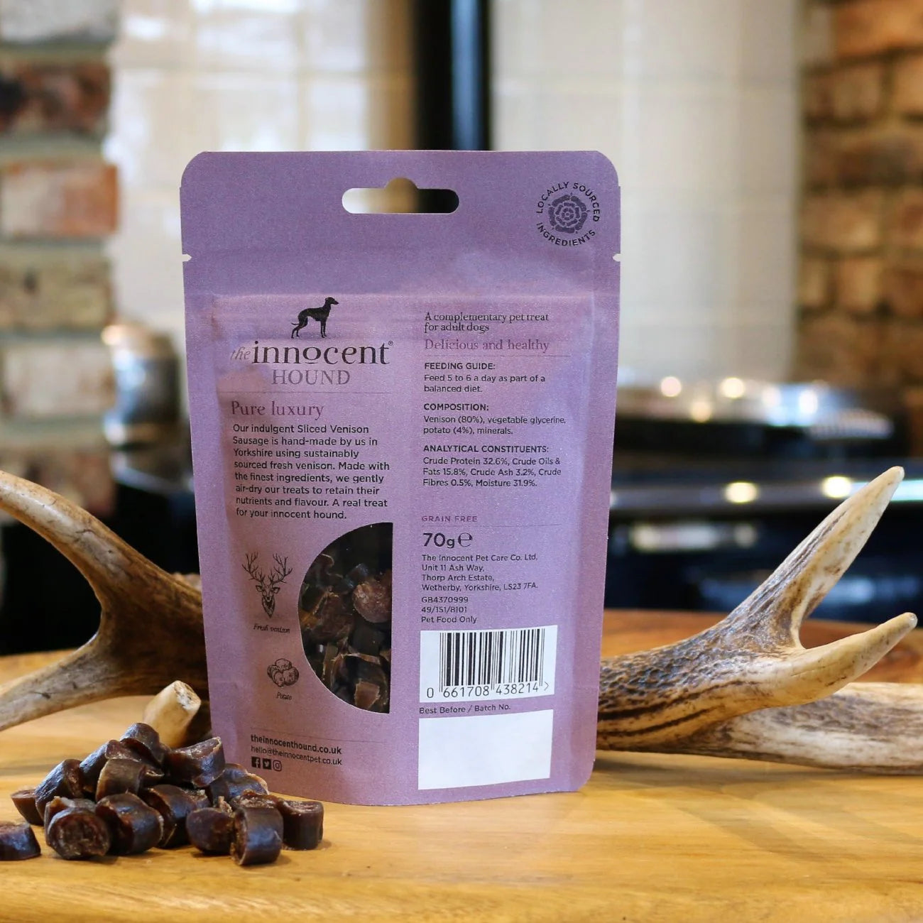 The back of the Innocent Hound Sliced Venison Sausage on a wooden surface with antlers.