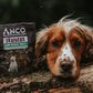 Dog lying on a log with an Anco Trainers treat package on a log.