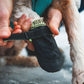 The Ruffwear Bark'n Boot Liners being adjusted on the paw by the dog's owner.