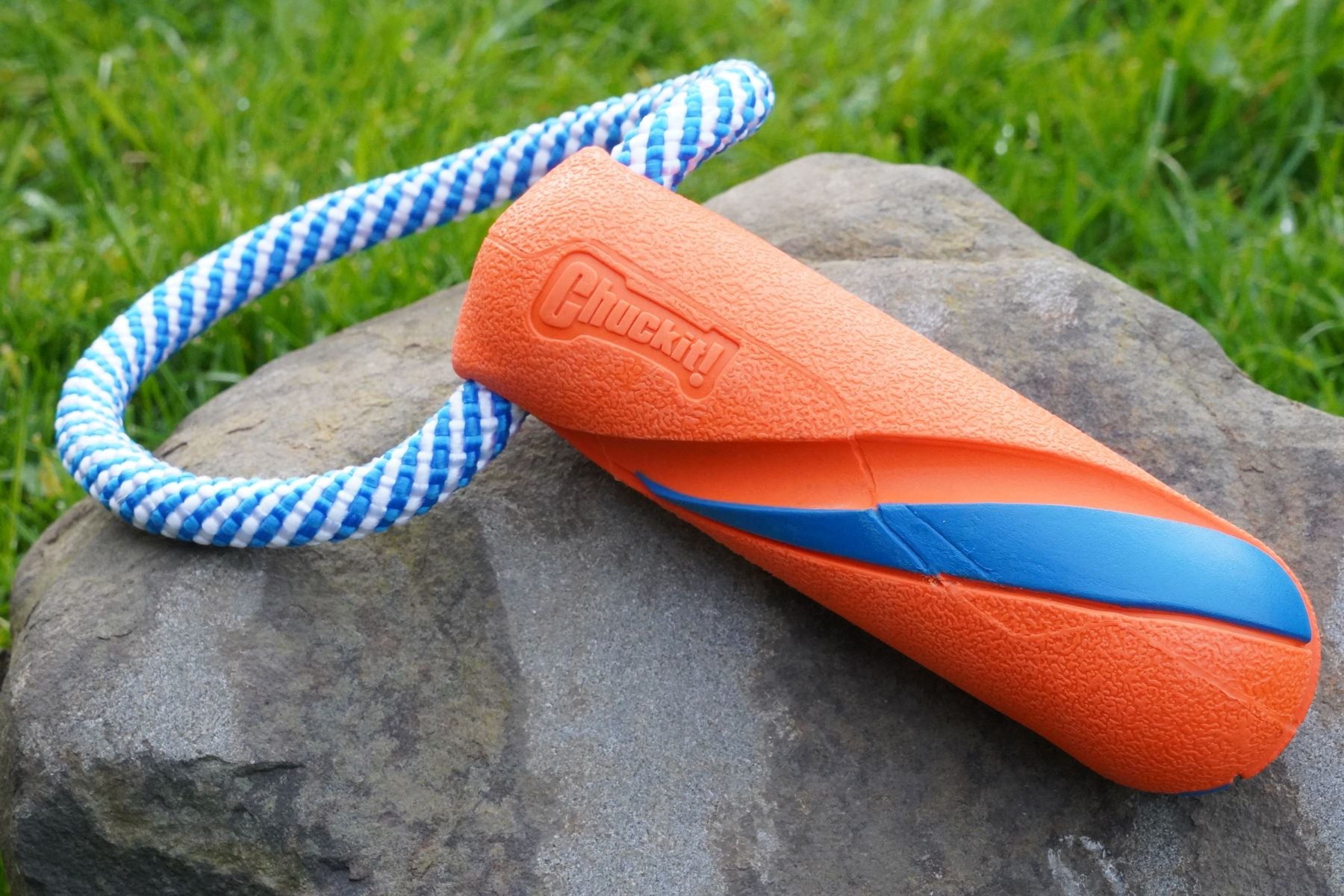 The Bumper Tug positioned on a rock. Orange and blue design, with a rope detail.