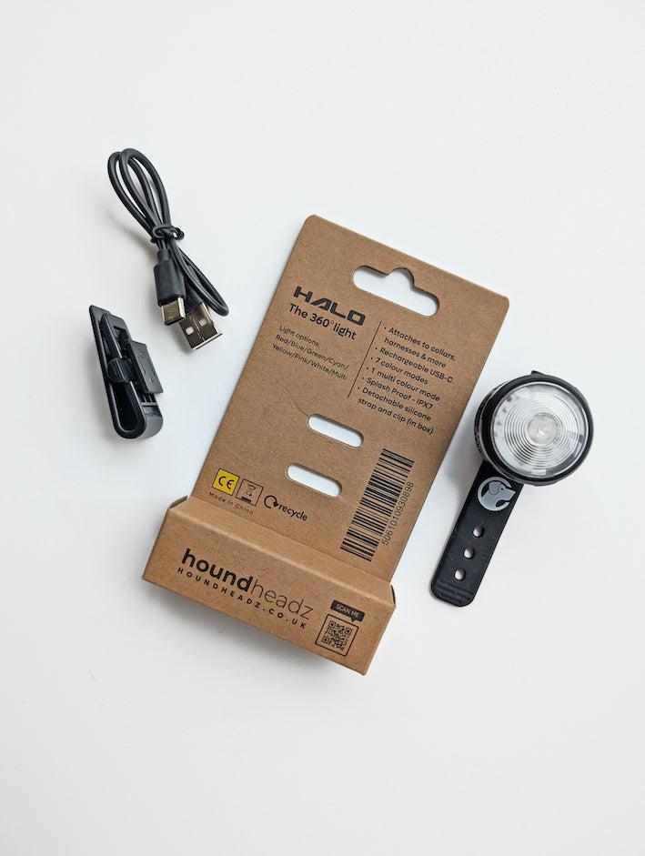 Stock image of the HoundHeadz Halo Light, with the chargers and light separated from the back of the packaging.