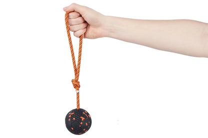 Hand holding a Ball on Rope against a white background.