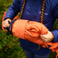Lifestyle image of the Bivvy Bag, a person holds the bag while wearing a Non-stop branded blue coat.