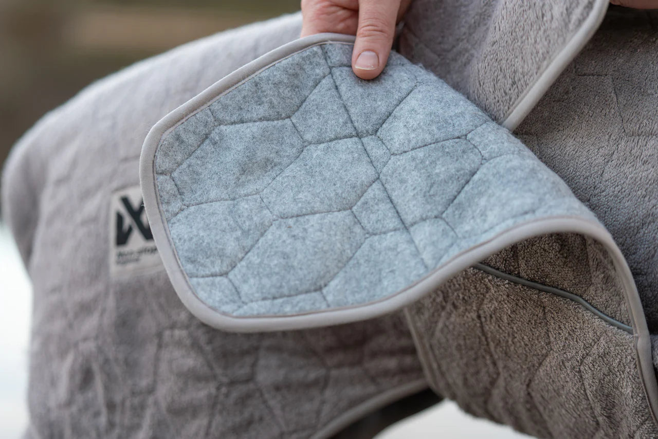 Lifestyle image of the Drying Robe, with a hand showing the details of the robe.