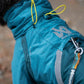 Lifestyle image of the Teal Fjord Overall, showing a lead feeding through the opening on the coat and attaching to a harness.