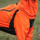 Lifestyle image of the Orange Fjord Overall, showing the shape of the coat against a grassy environment.