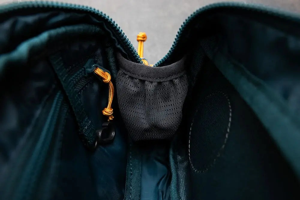 Lifestyle image of the Rachel Pohl Trail Quest Storage Pack, showing the zip and interior of the carrier.