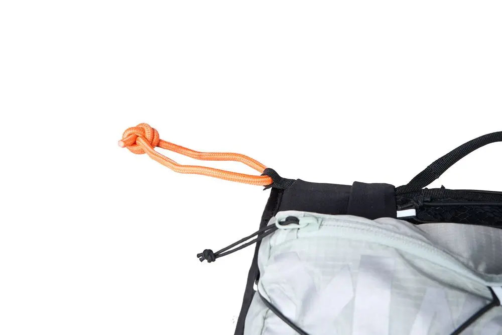 Detailed image of the Trail Light Backpack, a grey backpack with an orange lead attachment.
