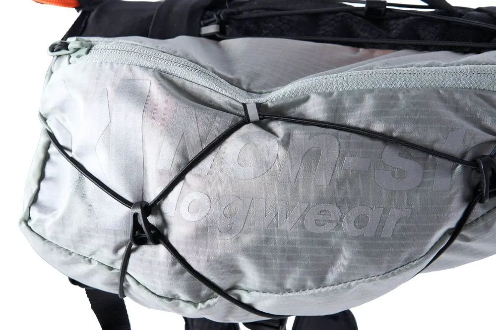 Detailed image of the Trail Light Backpack, a grey backpack with Non-stop branding along the side.