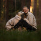 Dog and owner in a forest background, wearing matching colour fleece jackets.