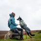 Lifestyle image of a dog and owner in an outdoor landscape. 