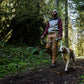Lifestyle image of the Crag EX Lead. worn by a brown and white dog walking down a forest trail, with the lead being held by their owner.