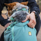 Lifestyle image of the Hitch Hiker Carrier, being adjusted around the neck of the dog.