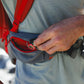 Lifestyle image of the Hitch Hiker Carrier, showing a hand placing keys into the compartment of the bag.