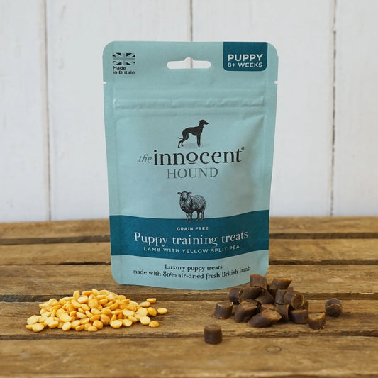 The Innocent Hound Puppy Training Treats on a wooden surface with treats displayed.