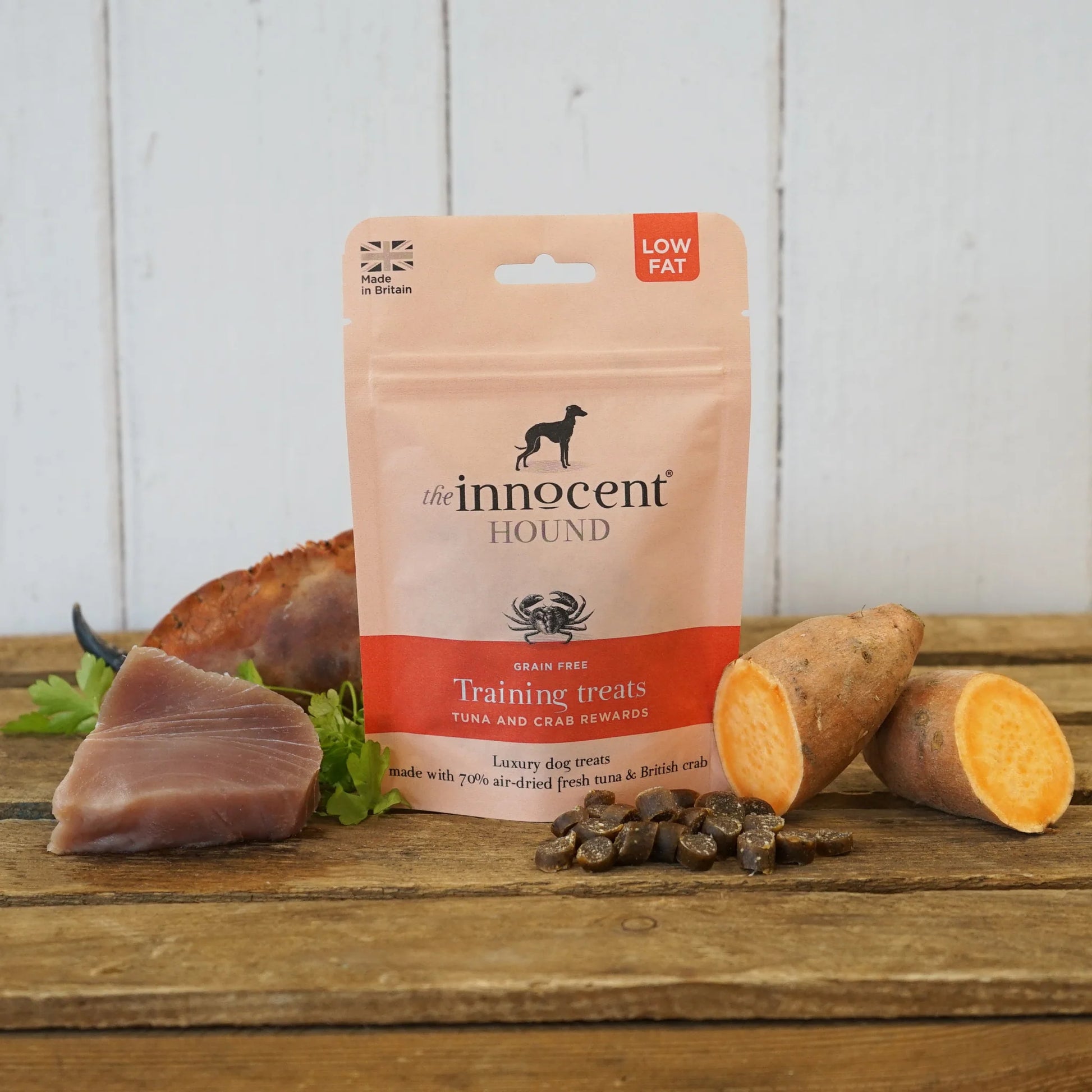 The Innocent Hound Training Crab and Tuna Treats are displayed on a wooden surface with treats and ingredients.