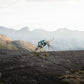 A dog wearing a Ramble Dog Harness Long and exploring some rocky mountains.