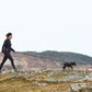Lifestyle image of the Trekking Belt 2.0, showing two dogs walking ahead of their owner, who wears the belt.