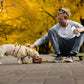 Lifestyle image of a dog and owner in the park, with the dog wearing the Flagline Harness and eating from a bowl.