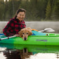 A dog and owner on a kayak, with the dog wearing the Float Coat lifejacket.