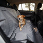 Dog laying down on the backseats of a car.